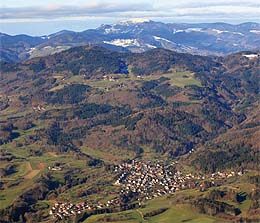 Über das Höhlendorf Hasel geht der Blick zur Hohen Möhr und zum schneebedeckten Belchen.